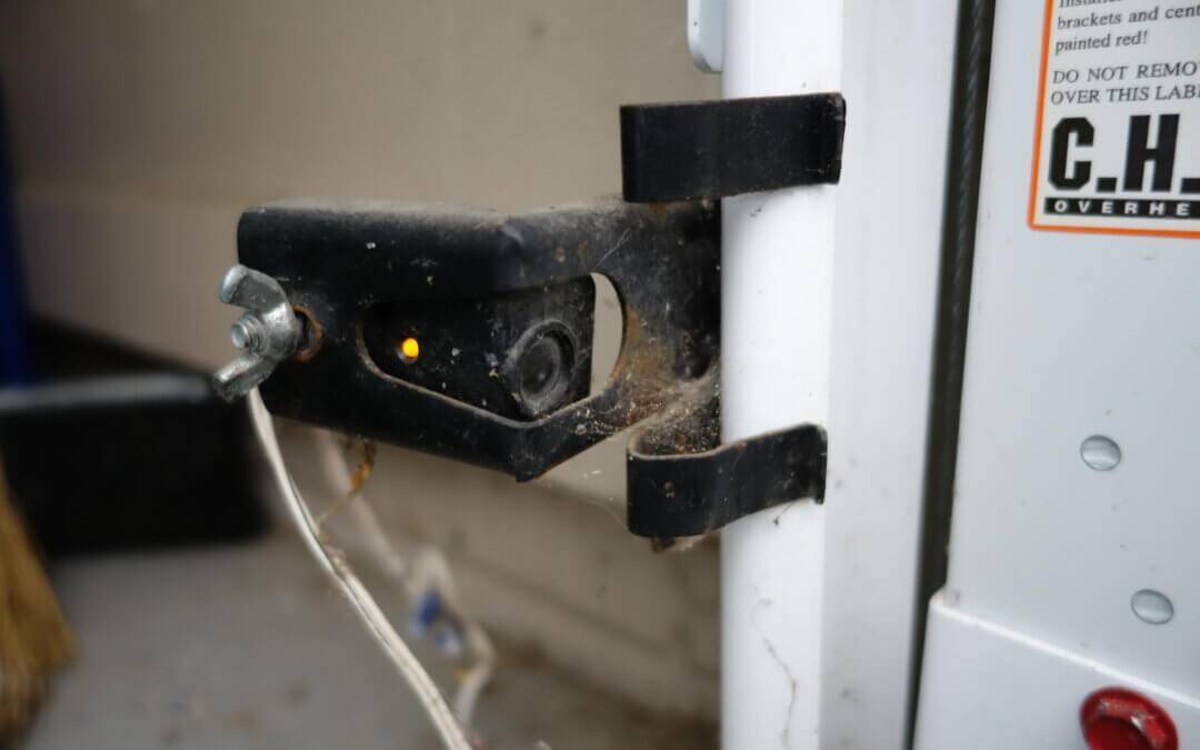 A garage door photo eye sensor that is dirty.